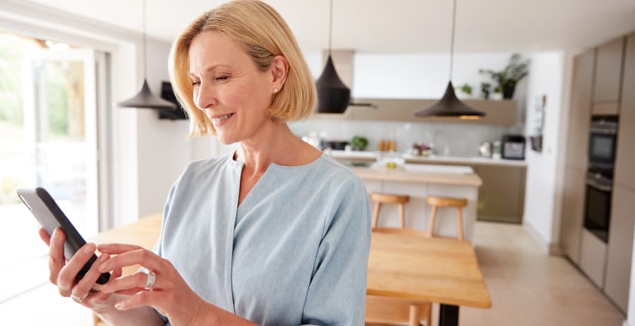 Homeowner with smartphone in a modern home